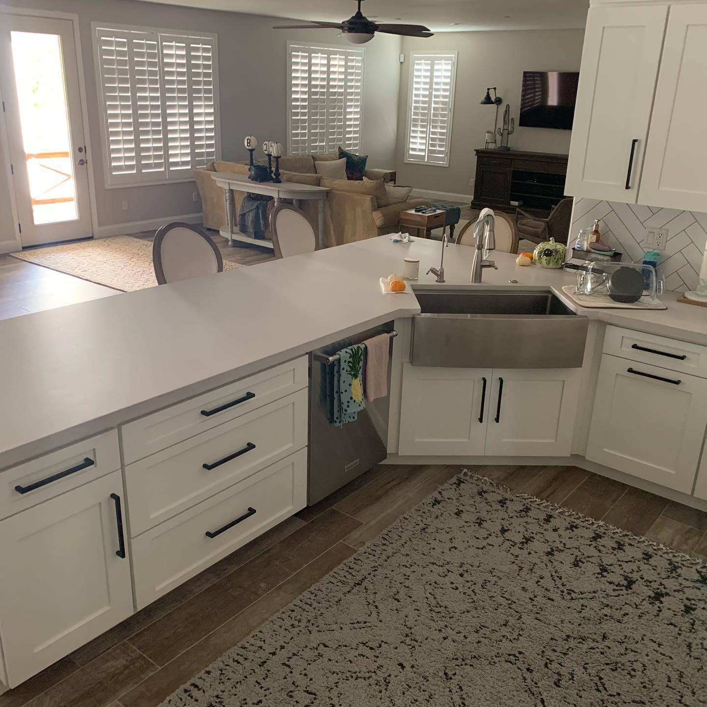 VM Stoneworks — White quartz peninsula countertop with stainless farmhouse sink