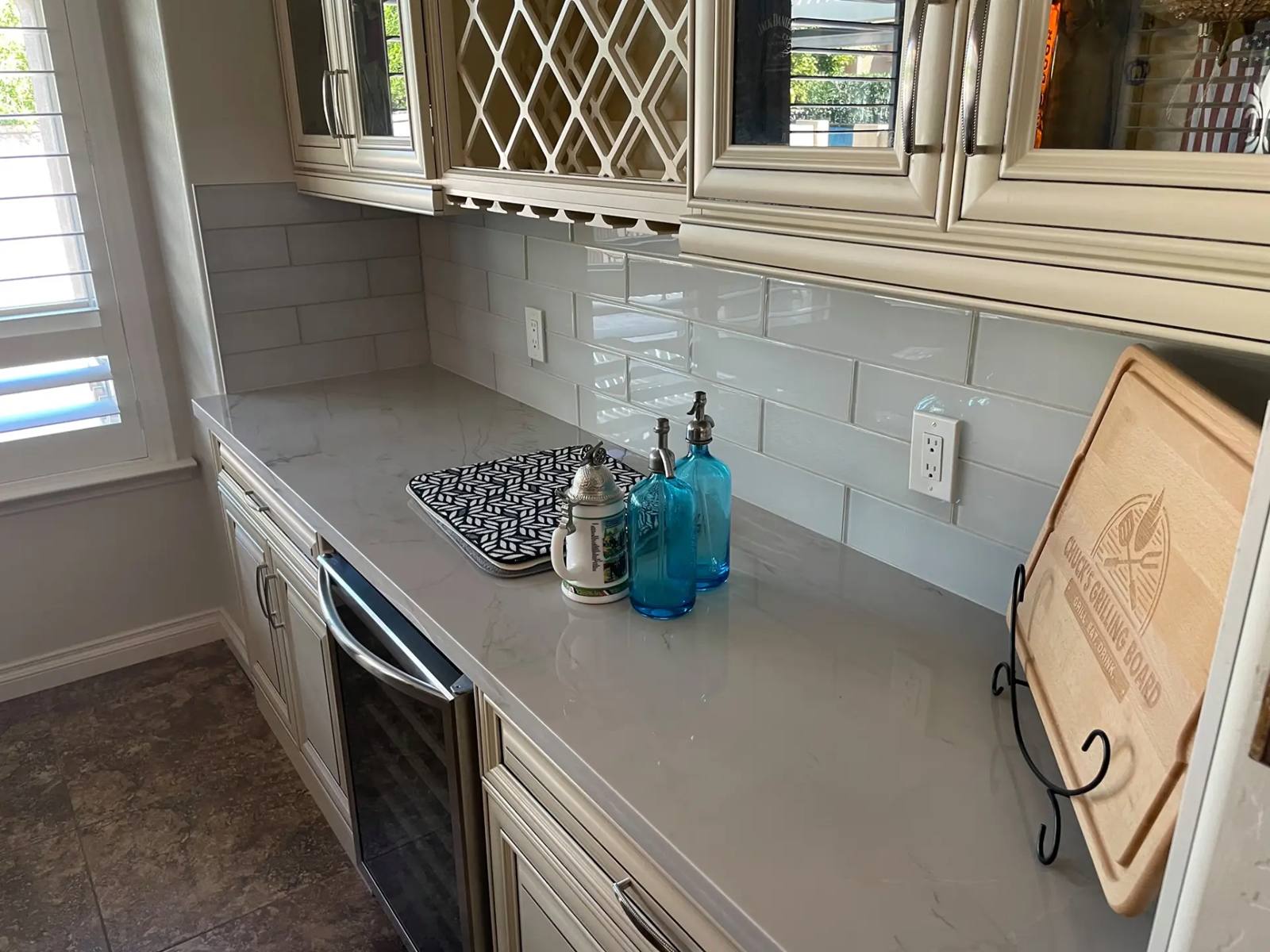 VM Stoneworks — Marble-look quartz counter with glass subway tile backsplash